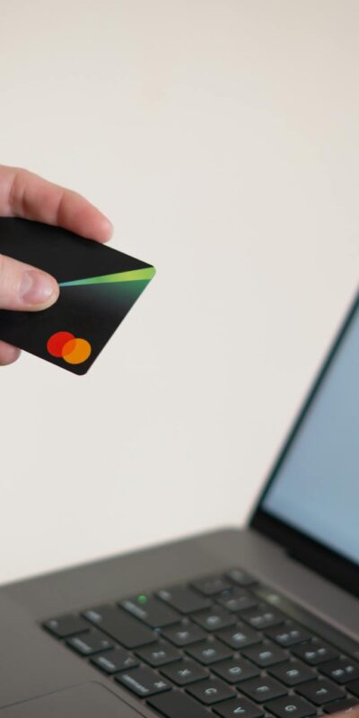 Woman holding credit card while shopping online, showcasing e-commerce convenience.